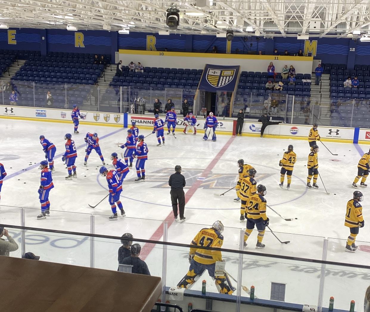Hockey players warm up before a game at Lawler Rink