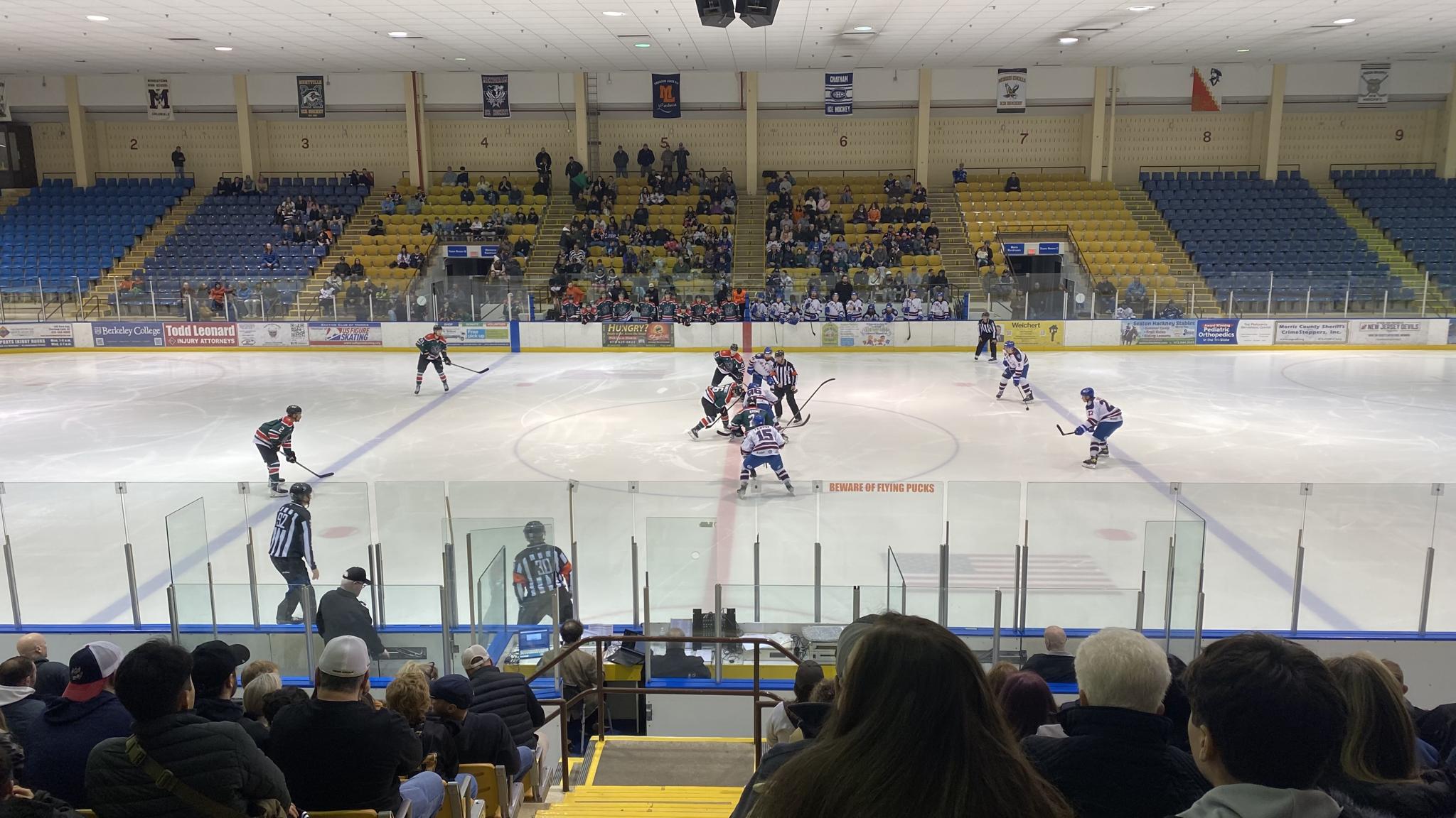 A photo of the opening faceoff of a hockey game at Mennen Sports Arena