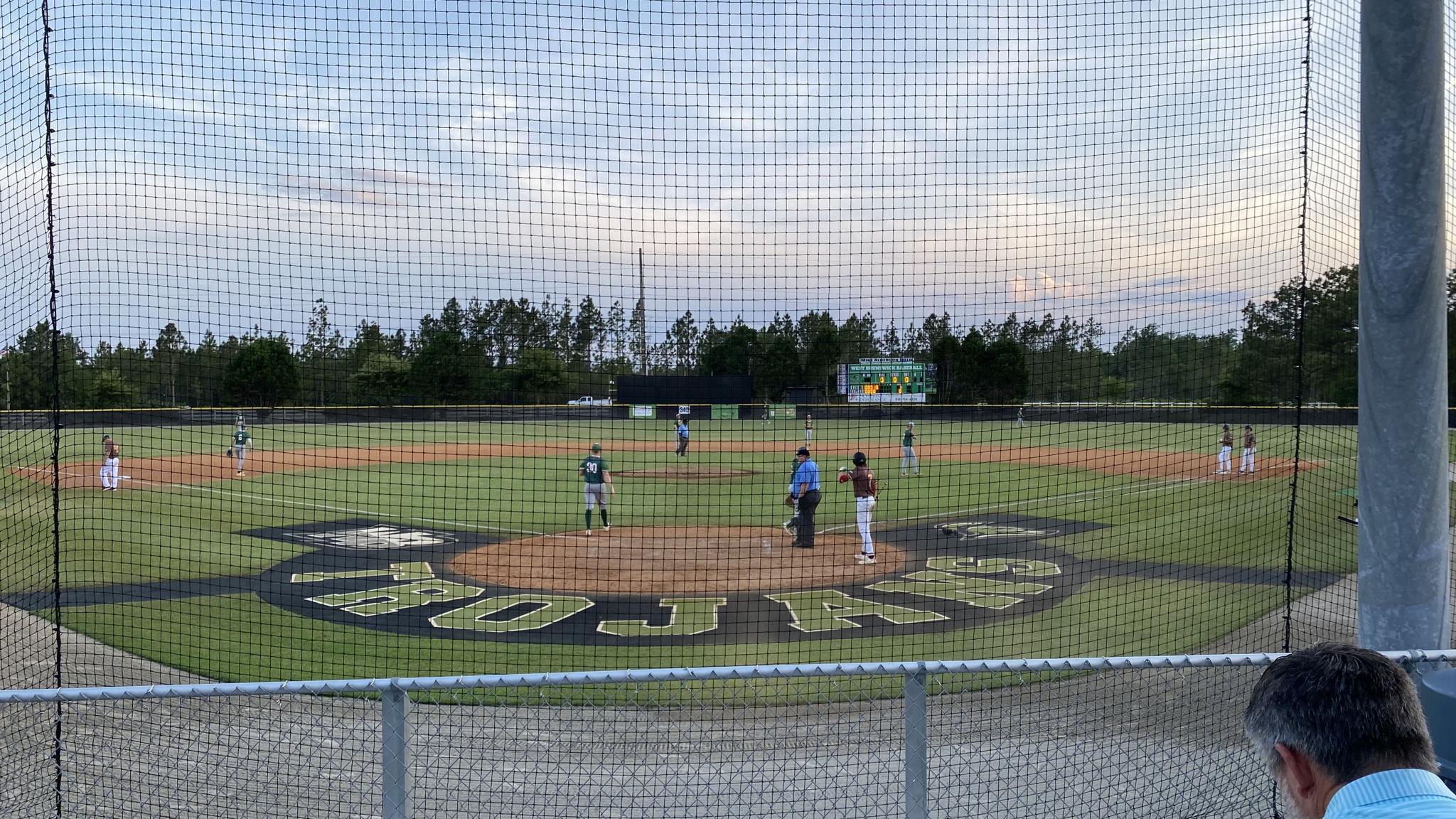 A photo of a baseball field with the first and third base lines featuring grass instead of dirt